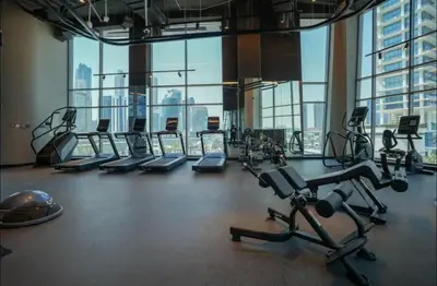 a gym with rows of treadmills and exercise bikes at Luxury Studio Business Bay Short Stays Long Stays in Dubai