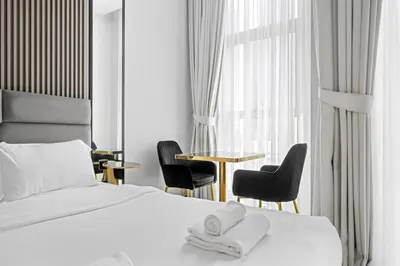 a hotel room with a bed and two chairs and a table at Luxury Studio Business Bay Short Stays Long Stays in Dubai