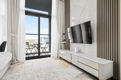 a living room with a tv on a wall at Luxury Studio Business Bay Short Stays Long Stays in Dubai
