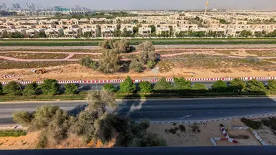 an aerial view of a city with a train on a road at Stylish MAG City Stay, Near Downtown and MBR City Attractions in Dubai