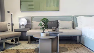 a living room with a bed and a table and a couch at Stylish MAG City Stay, Near Downtown and MBR City Attractions in Dubai