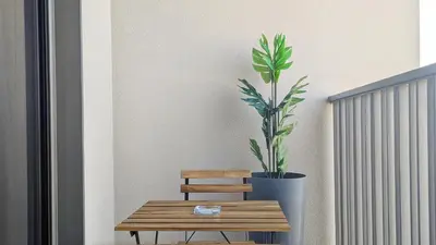 a wooden bench and a potted plant next to a plant at Stylish MAG City Stay, Near Downtown and MBR City Attractions in Dubai