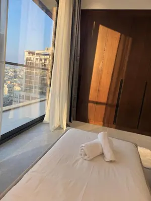 a bed with a towel on it in a room with a window at Luxury Brand new 2BR nearby DIFC in Dubai