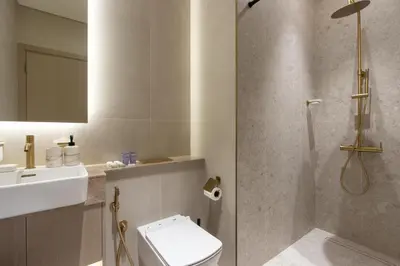 a bathroom with a shower and a toilet and a sink at Modern 1B with Private Jacuzzi Binghatti Phantom, JVC in Dubai