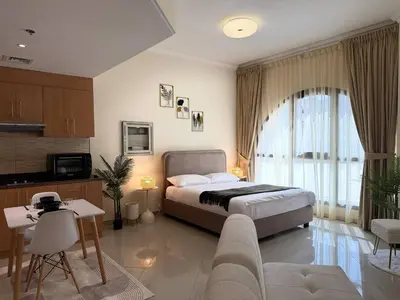 a bedroom with a bed and a living room at ASHRI HH | Spacious Studio in Arjan in Dubai