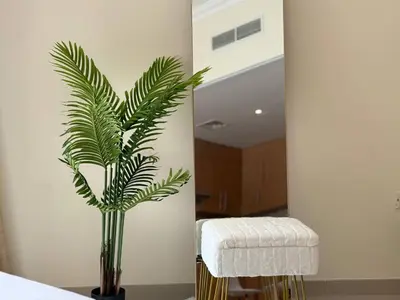 a palm plant in a vase in a room at ASHRI HH | Spacious Studio in Arjan in Dubai