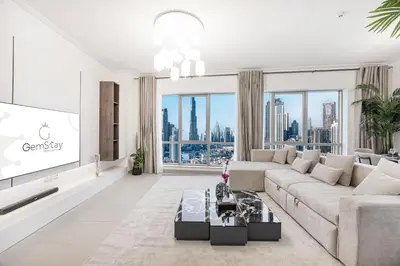 a living room with a couch and a tv at Full Burj Khalifa Fountain View Near Dubai Mall Downtown in Dubai