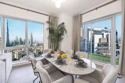 a dining room with a table and chairs and large windows at Full Burj Khalifa Fountain View Near Dubai Mall Downtown in Dubai