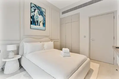 a white bedroom with a bed and a painting of a horse at MAG City Private Villa, 3BR with Pool, Garden & BBQ in Dubai