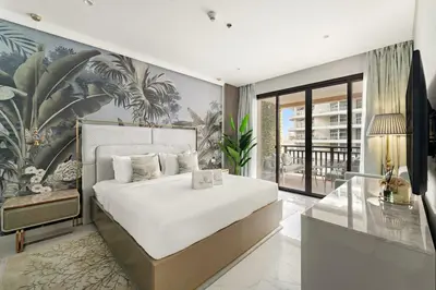 a bedroom with a large bed and a glass table at FIRST CLASS 1BR Serene Sea View Royal Amwaj in Dubai