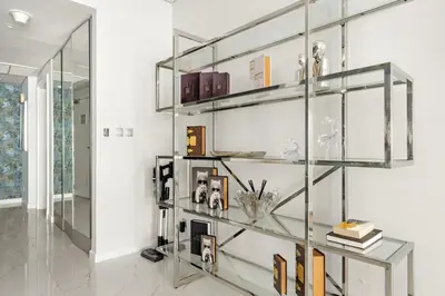a glass shelf in a room with books at FIRST CLASS 1BR Serene Sea View Royal Amwaj in Dubai