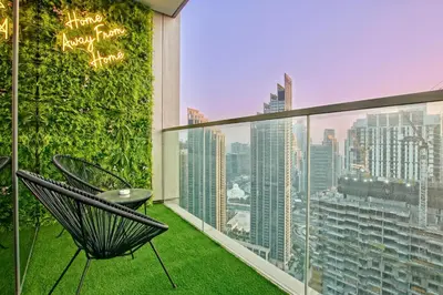 a balcony with a chair and a green wall at Luxury 1Bedroom Burj Khalifa View from Infinity Pool Grande Signature Residences in Dubai