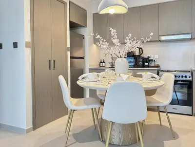a dining room with a table and chairs and a kitchen at Luxury 1Bedroom Burj Khalifa View from Infinity Pool Grande Signature Residences in Dubai