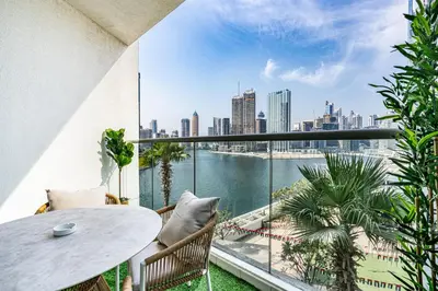 a balcony with a table and chairs and a view of the city at Sleek Home in Business Bay with Panoramic Views in Dubai