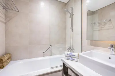 a bathroom with a tub and a sink and a shower at Sleek Home in Business Bay with Panoramic Views in Dubai