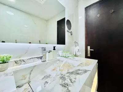 a bathroom with a marble counter and a black door at Cosmos Living Work-Friendly with Easy Metro Access in Dubai