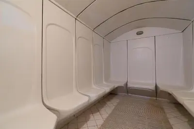 a bathroom with a row of white urinals at Cosmos Living Work-Friendly with Easy Metro Access in Dubai
