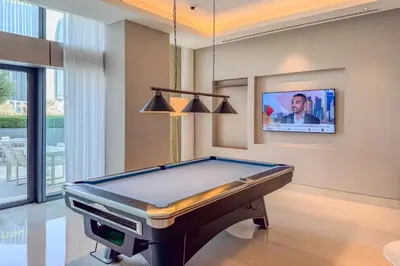 a pool table in a room with a tv at High-End 2Bedroom Near Dubai Opera & Mall in Dubai