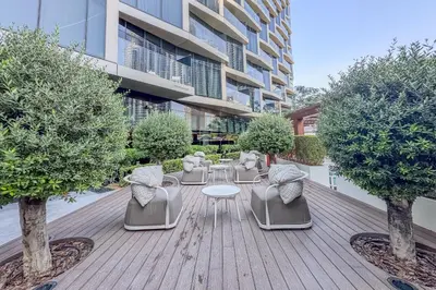 a patio with chairs and a table and trees at High-End 2Bedroom Near Dubai Opera & Mall in Dubai