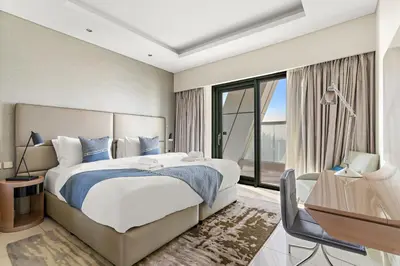 a bedroom with a bed and a desk and a window at VayK - Luxurious 3BR in Business Bay with Burj Khalifa View in Dubai