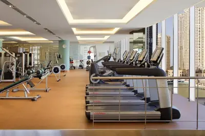 a gym with a row of tread machines at Incredible Views at The Address Dubai Marina 1BR in Dubai