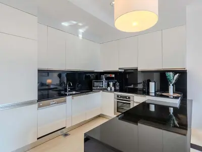 a kitchen with white cabinets and a black counter top at Incredible Views at The Address Dubai Marina 1BR in Dubai