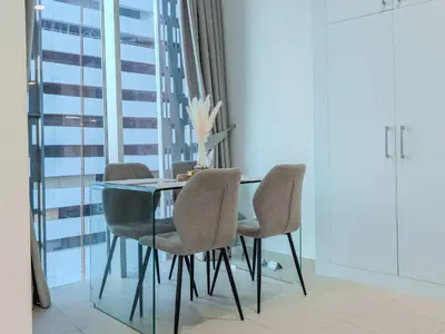 a dining room with a glass table and chairs at Cayan Tower, The Twist - Marina Views & Free Pool in Dubai