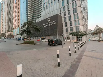 a parking lot in front of a large building at Cayan Tower, The Twist - Marina Views & Free Pool in Dubai