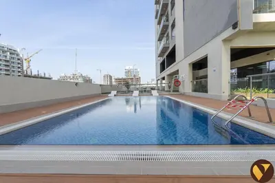 a swimming pool on the roof of a building at Vogue JVC Jeewar Tower Near Circle Mall, One Bedroom Apartment with Balcony and City View, Access to all Amenities in Dubai