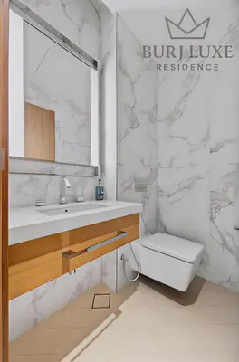 a bathroom with a sink and a toilet and a mirror at Address Residences Dubai Opera 3-bed Full Burj & Fountain View, Downtown Dubai in Dubai