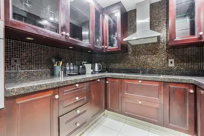 a kitchen with wooden cabinets and a counter top at Charming Oasis Near Dubai Mall & Burj Khalifa in Dubai
