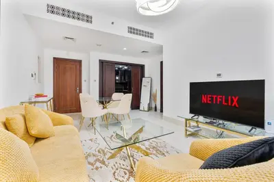 a living room with a couch and a tv at Charming Oasis Near Dubai Mall & Burj Khalifa in Dubai