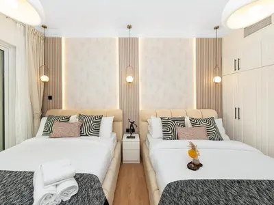 two beds in a room with white walls at New Lux 3BR Apartment High Floor Prime Location BCOM in Dubai