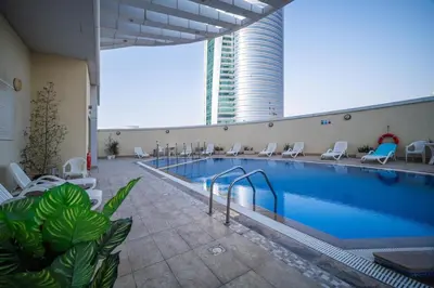 a large swimming pool with chairs and a building at Waves - Vibrant JLT Stay - Modern Funky Studio in Dubai
