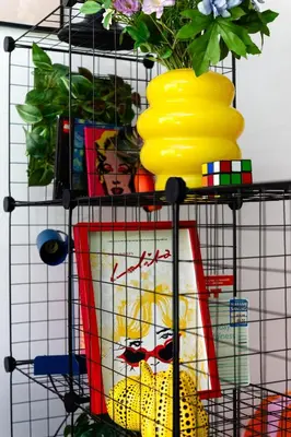 a wire wire shelf with a vase on top of it at Waves - Vibrant JLT Stay - Modern Funky Studio in Dubai