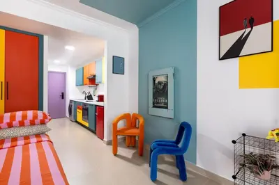 a colorful living room with two chairs and a couch at Waves - Vibrant JLT Stay - Modern Funky Studio in Dubai