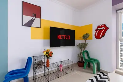 a room with two chairs and a television on a wall at Waves - Vibrant JLT Stay - Modern Funky Studio in Dubai