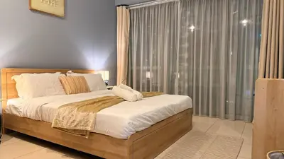 a bedroom with a bed and a large window at ASHRI HH | Elegant 2 BHK| Downtown Dubai | 8Blvd in Dubai