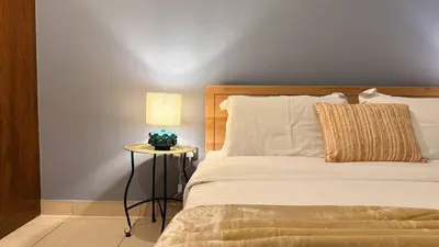 a bedroom with a bed and a table with a lamp at ASHRI HH | Elegant 2 BHK| Downtown Dubai | 8Blvd in Dubai