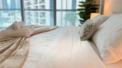 a white bed with white sheets and pillows at ASHRI HH | Elegant 2 BHK| Downtown Dubai | 8Blvd in Dubai