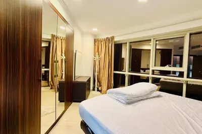 a bedroom with a large bed and a mirror at Cosy 1 Bed in JLT in Dubai