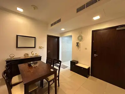 a dining room with a table and chairs and a bathroom at Cosy 1 Bed in JLT in Dubai