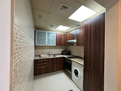 a kitchen with a washing machine and a washer at Cosy 1 Bed in JLT in Dubai