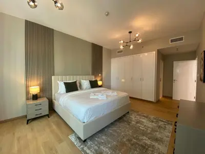 a bedroom with a large white bed and a rug at Comfy 1 Bedroom in Dubai Marina in Dubai