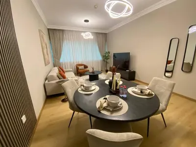 a living room with a table and chairs and a couch at Comfy 1 Bedroom in Dubai Marina in Dubai