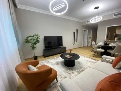 a living room with a couch and chairs and a tv at Comfy 1 Bedroom in Dubai Marina in Dubai