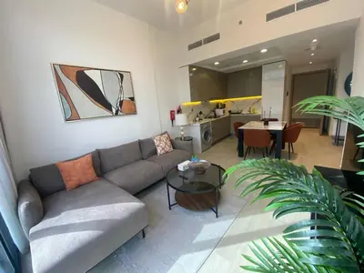 a living room with a couch and a table at Large 1 Bedroom Apartment in Azizi Riviera 15 in Dubai
