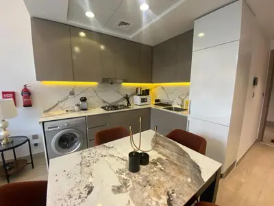 a kitchen with a marble table with chairs in it at Large 1 Bedroom Apartment in Azizi Riviera 15 in Dubai