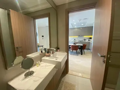 a bathroom with a sink and a mirror and a room at Large 1 Bedroom Apartment in Azizi Riviera 15 in Dubai