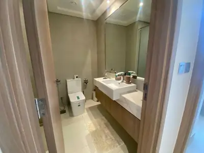 a bathroom with a sink and a toilet and a mirror at Large 1 Bedroom Apartment in Azizi Riviera 15 in Dubai